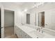 Modern bathroom featuring dual sinks, white cabinetry, and a large mirror with decorative lighting at 135 Emerald Ln, Roswell, GA 30075