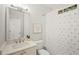 Bright bathroom with a white vanity, decorative mirror, and a shower with a patterned curtain at 135 Emerald Ln, Roswell, GA 30075