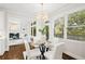 Charming dining area bathed in sunlight, featuring a glass table and views of backyard at 135 Emerald Ln, Roswell, GA 30075