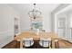 Bright dining room featuring hardwood floors, stylish chairs, and modern chandelier at 135 Emerald Ln, Roswell, GA 30075