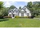 Charming two-story home showcasing a manicured lawn and well-maintained landscaping at 135 Emerald Ln, Roswell, GA 30075