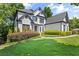 Beautifully landscaped front yard of a two-story home, featuring lush greenery and manicured bushes at 135 Emerald Ln, Roswell, GA 30075