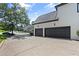 Attached two-car garage with an expansive driveway and beautiful landscaping at 135 Emerald Ln, Roswell, GA 30075