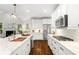 Stylish kitchen featuring white cabinets, marble countertops, stainless steel appliances, and hardwood floors at 135 Emerald Ln, Roswell, GA 30075