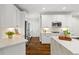 Well-lit kitchen with white cabinetry, stainless steel appliances, marble countertops, and hardwood floors throughout at 135 Emerald Ln, Roswell, GA 30075