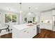 Modern kitchen island with pendant lighting, stainless appliances, and hardwood floors at 135 Emerald Ln, Roswell, GA 30075