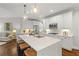 Bright kitchen with an island, stainless steel appliances, hardwood floors, and modern pendant lighting at 135 Emerald Ln, Roswell, GA 30075