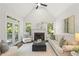 Inviting living room with high ceilings, a cozy fireplace, neutral furniture, and natural light streaming through the windows at 135 Emerald Ln, Roswell, GA 30075