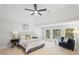 Bright main bedroom featuring a ceiling fan, sitting area, and large windows with natural light at 135 Emerald Ln, Roswell, GA 30075