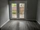 A room with neutral paint and wood-look floors and French doors to the patio at 1818 Ashborough Cir # E, Marietta, GA 30067