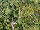 An aerial view displays a paved path through a green forest with a bridge crossing through the landscape at 6430 Banbury Se Ct, Mableton, GA 30126