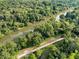 An aerial view displays the serene river running through a green forest with a bridge crossing through the landscape at 6430 Banbury Se Ct, Mableton, GA 30126