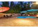 Inviting pool area at twilight, surrounded by lush greenery, seating, and stylish umbrellas at 6430 Banbury Se Ct, Mableton, GA 30126