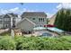 Backyard features a pool, patio area with dining set, lounge furniture, and mature trees at 6430 Banbury Se Ct, Mableton, GA 30126