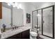 Modern bathroom featuring granite countertops, a glass-enclosed shower, and wood-look tile flooring at 6430 Banbury Se Ct, Mableton, GA 30126