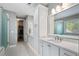 Bright bathroom featuring a double vanity, quartz countertops, shower, and closet at 6430 Banbury Se Ct, Mableton, GA 30126