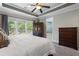 A bedroom features a large window for natural light, a tray ceiling, and neutral colored walls at 6430 Banbury Se Ct, Mableton, GA 30126