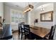 Well-lit dining area boasts sleek dark floors, wainscoting, and large windows covered by modern-style plantation shutters at 6430 Banbury Se Ct, Mableton, GA 30126