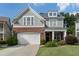 Charming two-story home boasts a brick and gray facade, complemented by a well-manicured lawn and a two-car garage at 6430 Banbury Se Ct, Mableton, GA 30126