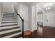 Entryway with dark wood floors, a staircase, and elegant trim, creating a welcoming and stylish first impression at 6430 Banbury Se Ct, Mableton, GA 30126