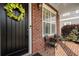 Inviting front porch with brick siding, a decorative wreath on the door, and cozy chairs for relaxing outdoors at 6430 Banbury Se Ct, Mableton, GA 30126
