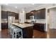 A kitchen featuring dark wood cabinetry, granite countertops, a stainless steel refrigerator, and a center island with seating at 6430 Banbury Se Ct, Mableton, GA 30126