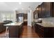 A modern kitchen featuring dark wood cabinetry, granite countertops, stainless steel appliances, and a large center island at 6430 Banbury Se Ct, Mableton, GA 30126