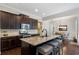 Open kitchen features dark wood cabinetry, granite countertops, stainless steel appliances, and a large center island with seating at 6430 Banbury Se Ct, Mableton, GA 30126