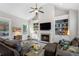 Bright living room with vaulted ceilings, built-in shelving, fireplace, hardwood floors, large windows, and a leather sofa at 6430 Banbury Se Ct, Mableton, GA 30126