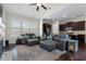 Open living room with vaulted ceilings, large windows, hardwood floors, dark wood cabinets, and a leather sofa at 6430 Banbury Se Ct, Mableton, GA 30126