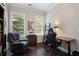 Bright office with a wooden desk, ergonomic chair, and view of the outdoor space at 6430 Banbury Se Ct, Mableton, GA 30126