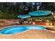 Backyard pool with lounge chairs, stylish umbrellas, manicured landscaping, and a relaxing atmosphere at 6430 Banbury Se Ct, Mableton, GA 30126