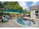 An in-ground pool is surrounded by comfortable outdoor seating, shade umbrellas, and professional landscaping at 6430 Banbury Se Ct, Mableton, GA 30126