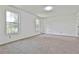 Spacious bedroom featuring plush carpet, two windows providing natural light, and freshly painted walls at 100 Walnut Ct, Stockbridge, GA 30281