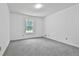 Bedroom with plush carpeting and a bright window, offering a comfortable and inviting space at 100 Walnut Ct, Stockbridge, GA 30281
