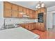Traditional kitchen features wood cabinets, laminate countertops, and stainless steel sink with modern light fixture at 100 Walnut Ct, Stockbridge, GA 30281