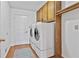 Laundry room with front load washer and dryer, overhead cabinet and wood look floors at 100 Walnut Ct, Stockbridge, GA 30281