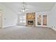 Spacious living room with plush carpet, stone fireplace and natural light flowing through the windows at 100 Walnut Ct, Stockbridge, GA 30281