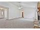 Open-concept living room with plush neutral carpeting and a decorative stone fireplace at 100 Walnut Ct, Stockbridge, GA 30281
