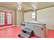 Enclosed sunroom showcasing a hot tub with steps, red painted floors, and natural light at 100 Walnut Ct, Stockbridge, GA 30281
