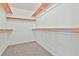 Spacious walk-in closet featuring carpeted floors and wooden shelves for optimal organization and storage at 100 Walnut Ct, Stockbridge, GA 30281