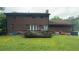 View of backyard showing the home's brick exterior, a wooden deck, and lush green grass at 1095 Mitchell Crossing Sw Dr, Atlanta, GA 30331