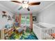 Bright Bedroom featuring a crib, rocker, and windows offering views of the landscaped yard at 2123 Garden Cir, Decatur, GA 30032