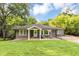 Charming single-story home with well-manicured lawn, mature trees and a cozy front porch with seating at 2123 Garden Cir, Decatur, GA 30032