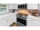 Updated kitchen with stainless steel gas range and white cabinets at 2123 Garden Cir, Decatur, GA 30032