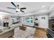 Bright living room with a large window, hardwood floors, tray ceilings, and a modern ceiling fan at 2123 Garden Cir, Decatur, GA 30032