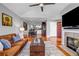 A well-lit living room with a fireplace, leather sofa, and a view of the kitchen at 22107 Harvest Ridge Lane # 22, Alpharetta, GA 30022