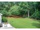 Lush, green backyard featuring mature trees and patio area, perfect for relaxation and outdoor entertaining at 3030 Larkspur Ct, Cumming, GA 30041