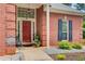 Inviting front porch with a red door, brick facade, and decorative landscaping at 3030 Larkspur Ct, Cumming, GA 30041