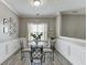 Bright dining room with crown molding, wainscotting and a modern glass table with metal chairs at 3153 Morgan Box Ne Ln, Buford, GA 30519